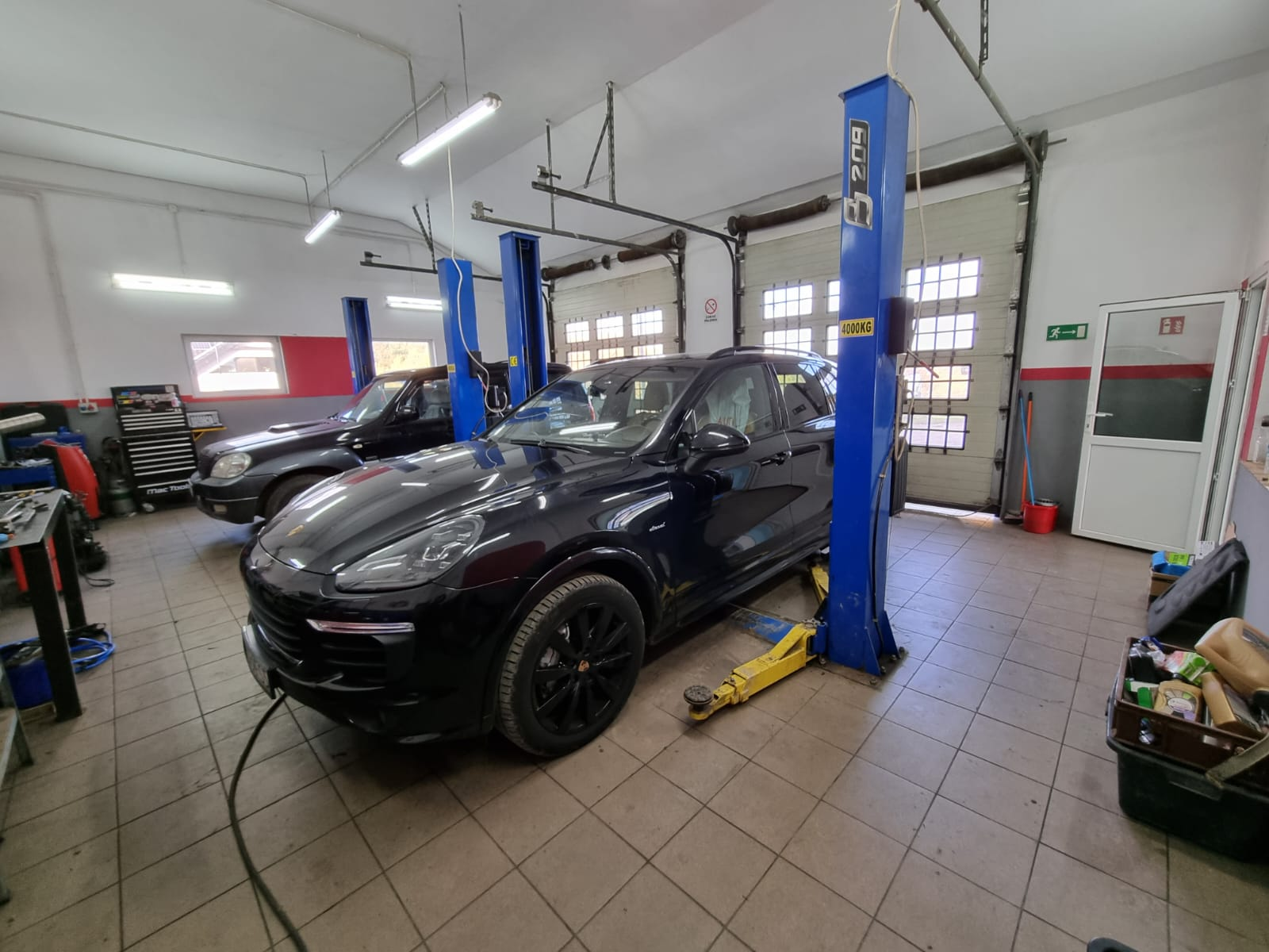 Czarne Porsche na stanowisku obsługi mechanicznej w warsztacie
